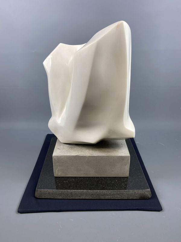 a small abstract white marble sculpture by Jack Kehoe that resembles drapery
