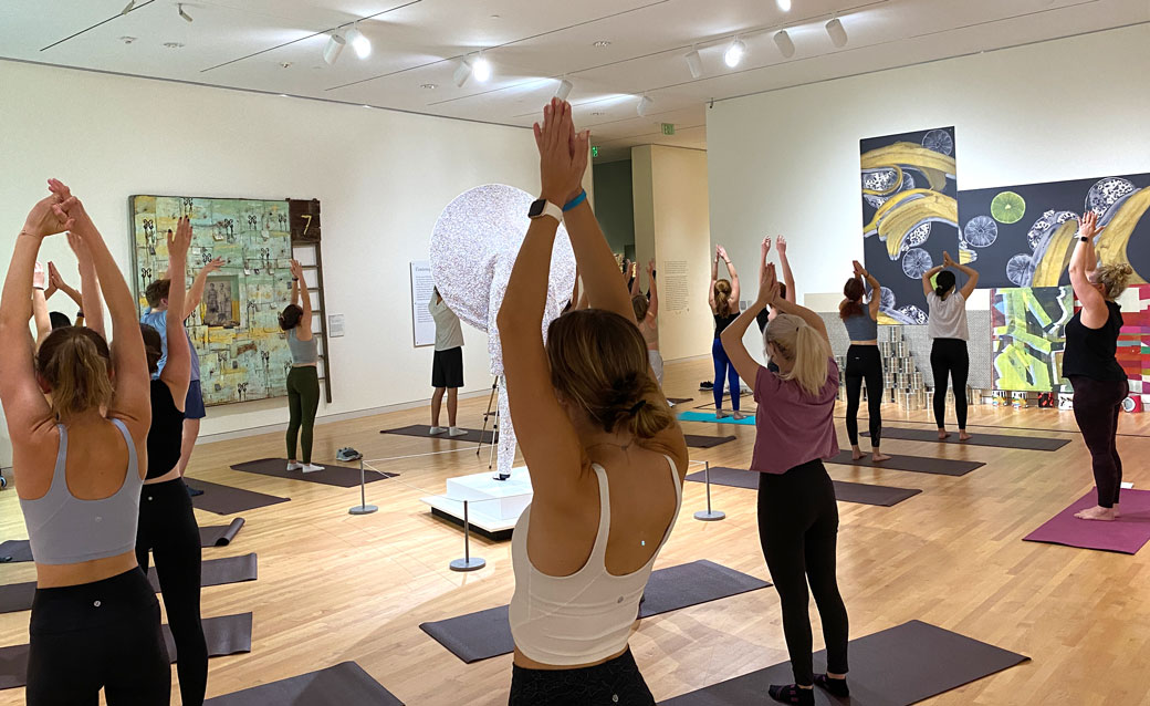 people doing yoga in the museum's galleries