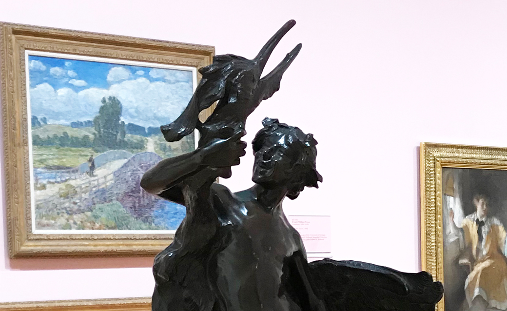 detail of a gallery shot at the museum, showing a realistic sculpture by Frederick Macmonnies in the foreground